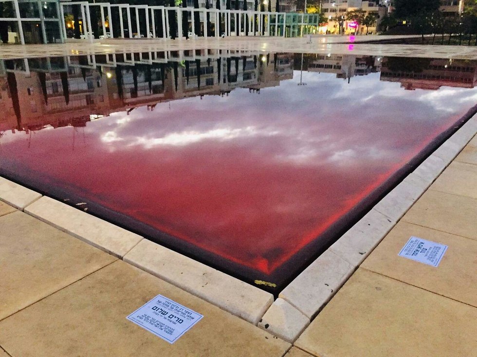 A fountain in the Tel Aviv Habima Sqaure filled with red paint, in protest of the recent muders of women by their husbands around the country. December 2018. (Photo:  Claudia Levin)