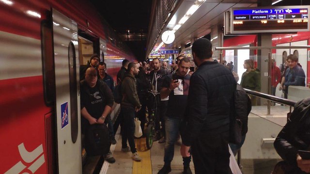 רכבת פרברית לפרדס חנה עצרה באמצע הדרך בגלל הפגנה, הנוסעים שלה מנסים לעלות לרכבת אחרת שלא אמורה לעצור להם בפרדס חנה (צילום: מור גולדברג)