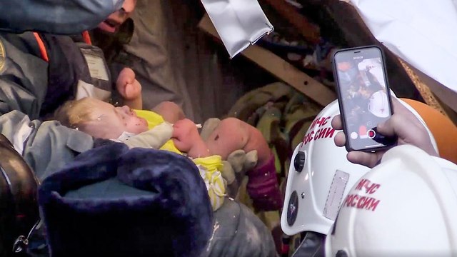 תינוק חולץ מהריסות בניין שקרס בעיר מגניטוגורסק רוסיה (צילום: AP)