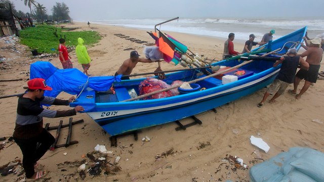 Жители Таиланда убирают лодки на берег. Фото: AP