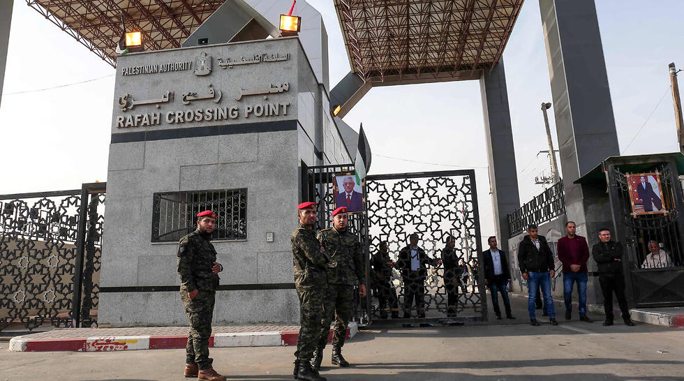 Hamas security forces at Rafah border crossing, where portraits of Abbas and Egyptian President al-Sisi are featured prominently. (Photo: AFP)