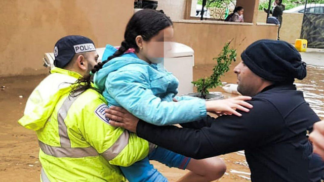 שוטרים עוזרים להוציא ילדים נזקים שנקלעו בשלוליות בעקבות הגשם בטמרה ()