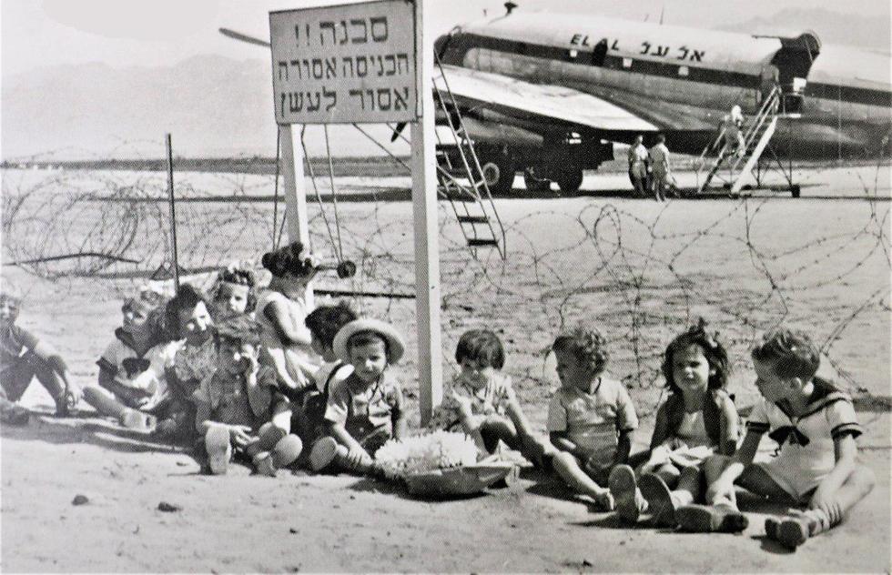 ילדי אילת מחכים בשדה התעופה באילת לראש הממשלה דוד בן גוריון, ברקע מטוס אל על, 1952 (צילום מתוך אלבומי רשות שדות התעופה)