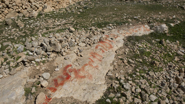 Hebrew graffiti is seen on a rock, that Palestinian villagers say was made by neighboring Israeli settlers