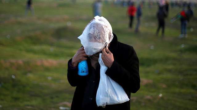 פלסטינים מפגינים בגבול הרצועה (צילום: רויטרס)
