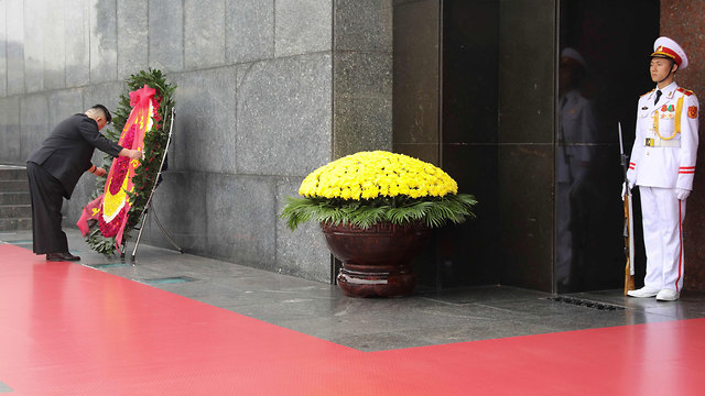 שליט קוריאה, קים ג'ונג און, מניח זר לזכרו של הגיבור הויאטנמי הו צ'י מין באנדרטה בהאנוי (צילום: AFP)