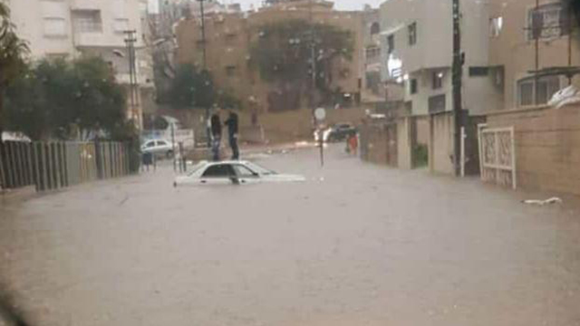 Car stuck in floods in Tayibe