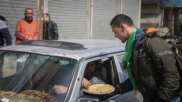 חמאס מחלק ממתקים על הפיגוע בחאן יונס ()