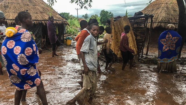  Inhabitants of Chiluvi, a village in central Mozambique, walk along a flooded and muddy street after Cyclone Idai and Floods (Photo: EPA)
