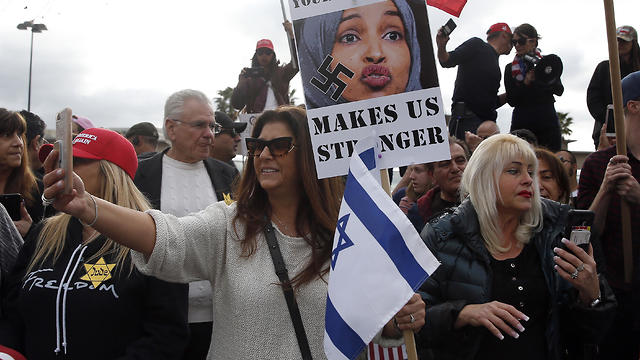 Protesters hold placards and flags during a demonstration against Ilhan Omar, US Representative for Minnesota's 5th congressional district, in Woodland Hills, Los Angelesm California