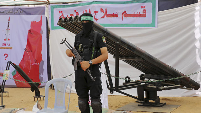 A Hamas fighter standing by rocket launchers 