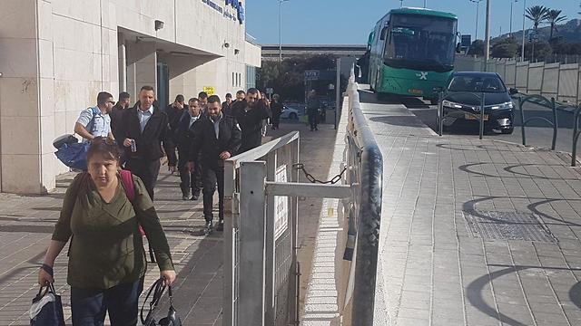 נוסעים יורדים מהרכבת לשאטלים בתחנת חיפה חוף הכרמל (צילום: אחיה ראב