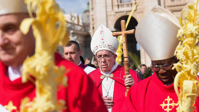 Pope Francis walks along Cardinals across St. Peter's square as he celebrates the Palm Sunday mass 