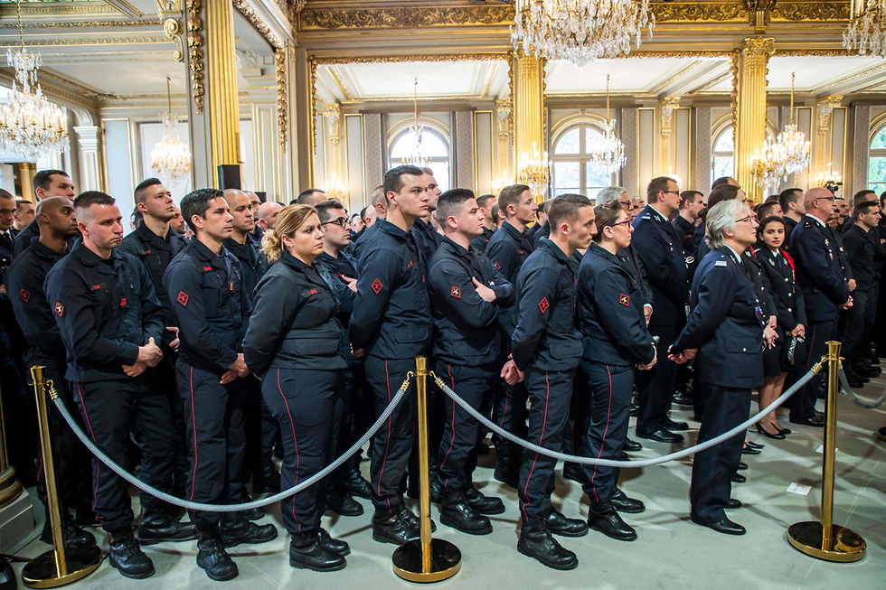 חטיבת מכבי האש של פריז מקשיבים לנאומו של נשיא צרפת, עמנואל מקרון (צילום: AFP)