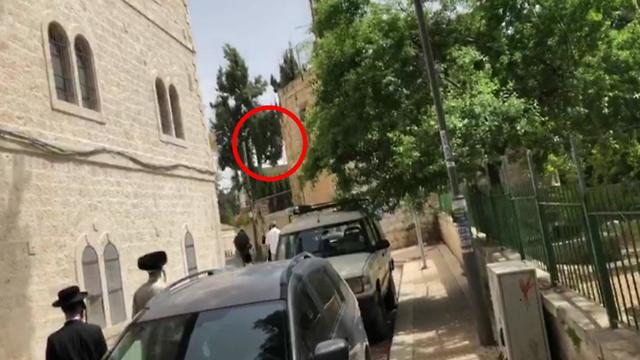 התגודדות של עשרוות חרדים סביב חייל במדים בשכונת מאה שערים בירושלים ()
