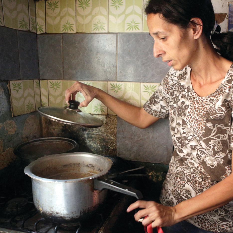 תמונות יום־יום בפטארה, הסלאם העני ביותר בקראקס: אישה מבשלת בסיר כמעט ריק, ילדים אוכלים מרק שנתרם לבית התמחוי המקומי