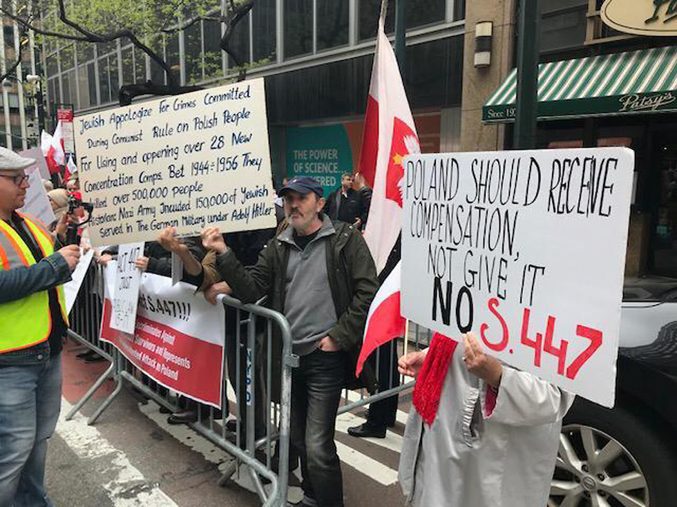 "Польша должна получить компенсацию, а не выплачивать ее" - плакат на демонстрации в Нью-Йорке