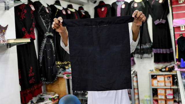 A salesman shows a full face veil, niqab, at a shop selling various kinds of coverings worn by Muslim women in Colombo, Sri Lanka. (Photo: Reuters)