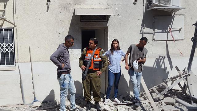 Семья Мецарфи у дома в Ашкелоне, поврежденного разрывом ракеты