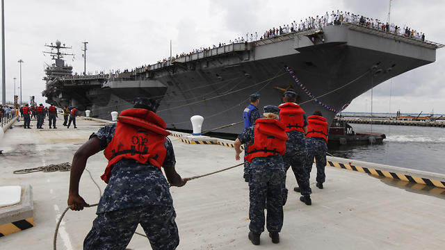 Navy shore crew hauls in lines of the USS Abraham Lincoln at Norfolk VA