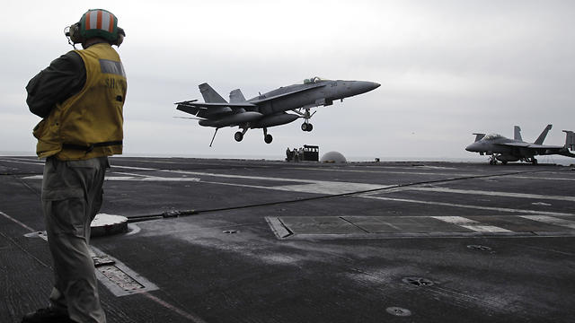 A fighter jet lands on the USS Abraham Lincoln