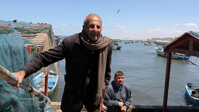 Palestinian fisherman Mahmoud Al-Assi, 73, who said that he was expelled with his family from Jafa when Israel was founded in 1948, walks at the seaport of Gaza City