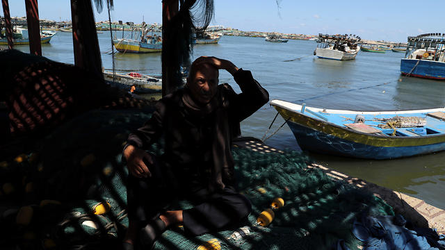 Palestinian fisherman Mahmoud Al-Assi, 73, who said that he was expelled with his family from Jafa when Israel was founded in 1948, sits at the seaport of Gaza City