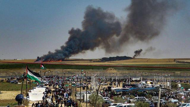 Беспорядки на границе Газы (на заднем фоне пожар на территории Израиля)