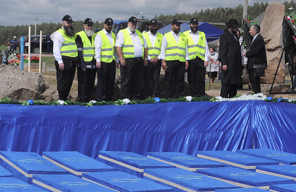ZAKA volunteers stand in front of mass grave 