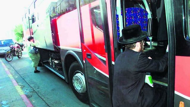 A woman boards at the back of a bus in the predominantly Ultra-Orthodox city of Bnei Brak (Photo: Shaul Golan)