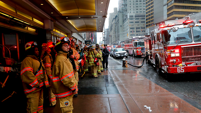 Пожарные у входа в здание, на которое упал вертолет. Фото: AP