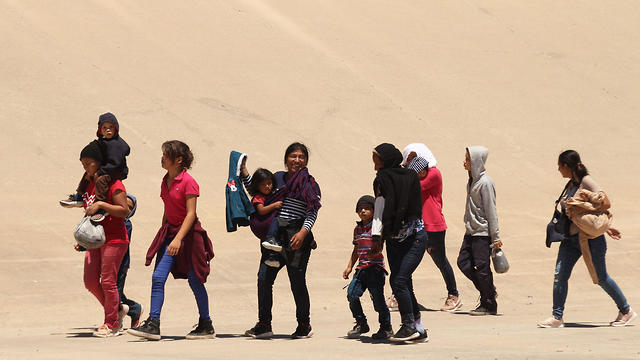 מהגרים חוצים את הגבול ממקסיקו לארצות הברית בטקסס (צילום: AFP)