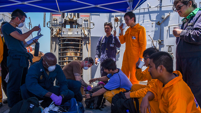 צוות המכלית היפנית שחולץ מקבל טיפול  רפואי על סיפון משחתת אמריקנית במפרץ עומאן (צילום: EPA)