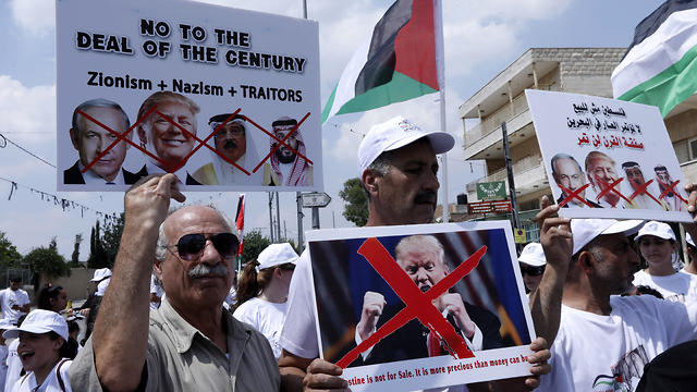 Palestinians hold a poster against the US President Donald Trump, the Bahraini king Hamad Bin Isa Al Khalifa and Prime Minister Benjamin Netanyahu in Bethlehem, West Bank 
