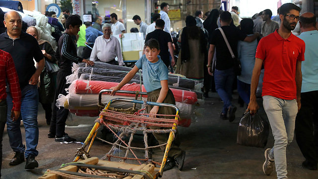 A young worker takes a break on his cart at the old main bazaar in Tehran, June 23, 2019  (Photo: AP)
