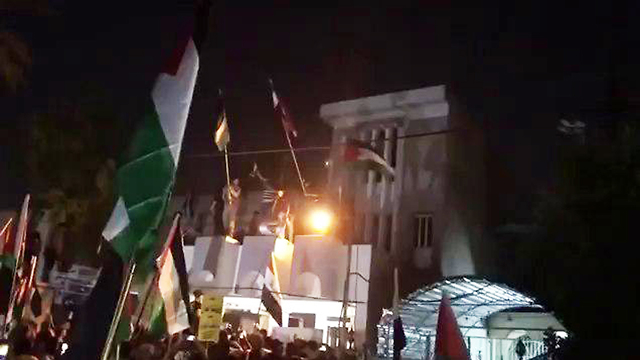 מהומות עיראק טיפסו על גג שגרירות בחריין מחאה נגד הסדנה הכלכלית (מתוך עמוד יוטיוב)