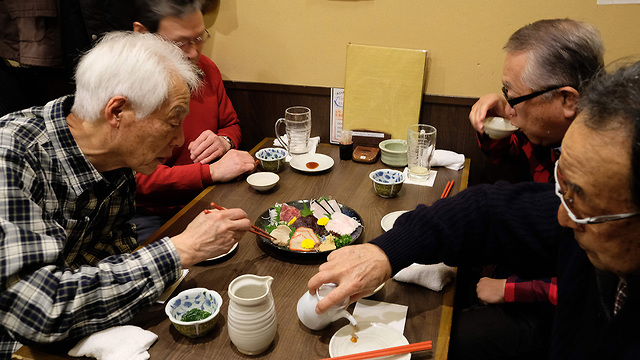יפן חידוש ציד לווייתנים אחרי 30 שנה אוכלים בשר לווייתן ב מסעדה טוקיו (צילום: AFP)