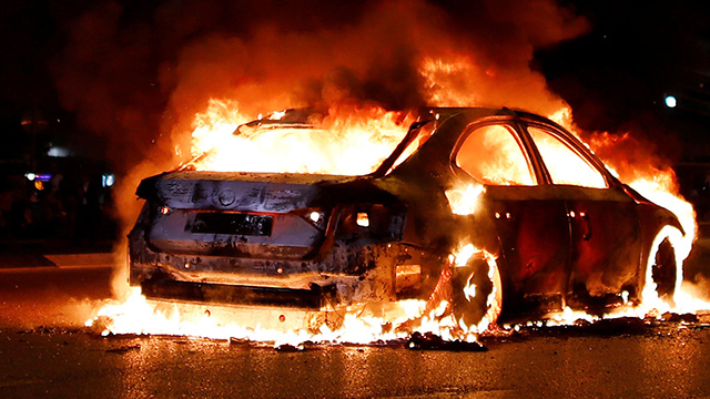 A car burns during protests outside Azrieli shopping mall in Tel Aviv (Photo: Reuters)