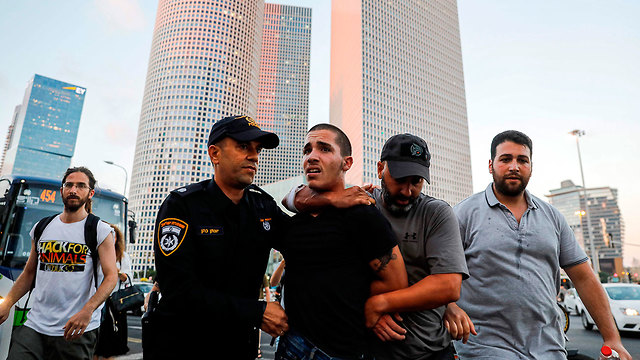 Задержание участника беспорядков в Тель-Авиве. Фото: AFP