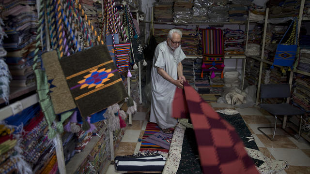 Palestinian Mahmoud al-Sawwaf, the owner of a traditional carpets factory, displays his products in Gaza City (Photo: AP)