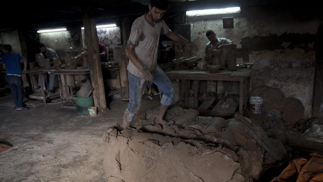  Palestinian worker prepares the clay at a pottery workshop in Gaza City (Photo: AP)