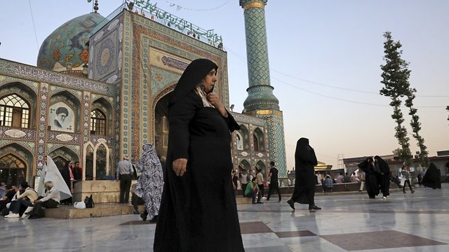 A head-to-toe veiled woman walks in the courtyard of the shrine of Saint Saleh in northern Tehran