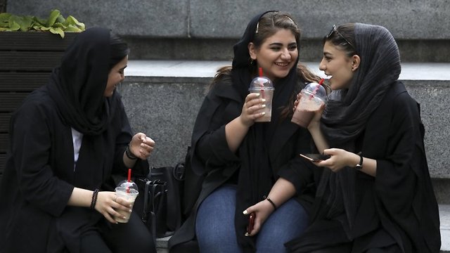 Youngsters spend an afternoon while siting on steps outside a shopping mall in northern Tehran