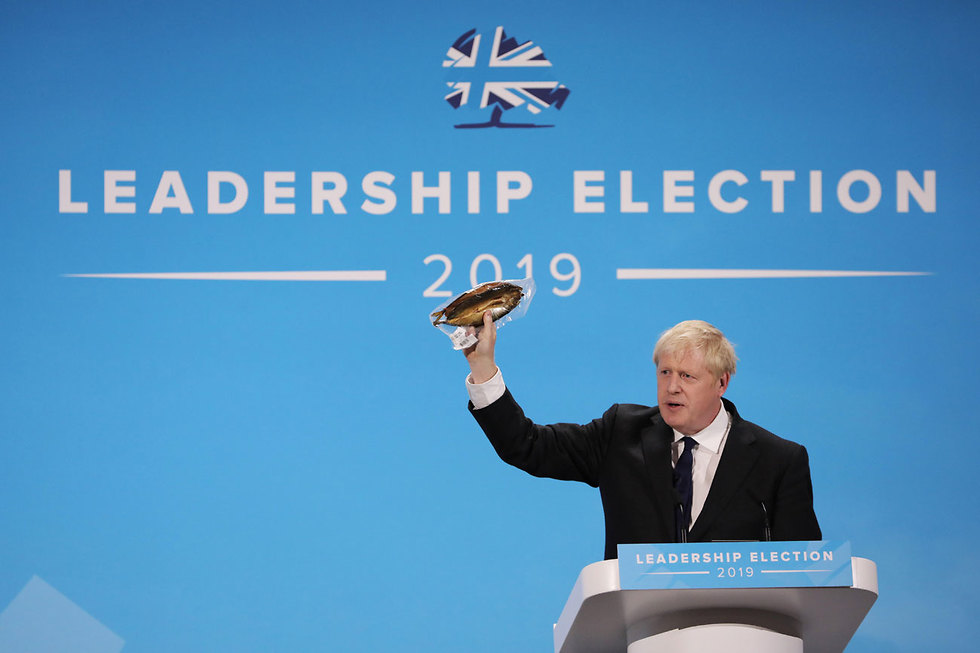 בוריס ג'ונסון מניף דג מעושן נאום למפלגה השמרנית לונדון בריטניה  (צילום: gettyimages)