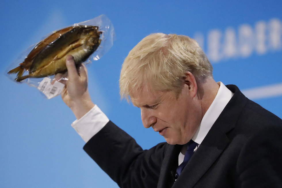 בוריס ג'ונסון מניף דג מעושן נאום למפלגה השמרנית לונדון בריטניה  (צילום:AFP)
