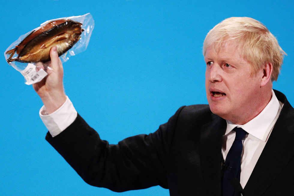 בוריס ג'ונסון מניף דג מעושן נאום למפלגה השמרנית לונדון בריטניה  (צילום: gettyimages)