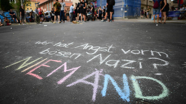  'Who fears the bad Nazi? Nobody' is written in the ground with colorful chalk during a demonstration against the Identitarian Movement