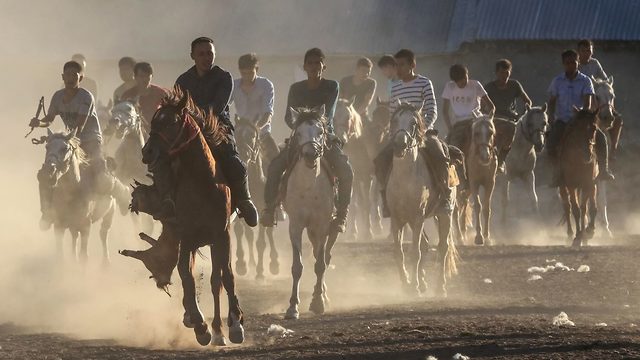 A mounted Kyrgyz Turk carries a dead goat as he’s pursued by others during a game of Buzkashi in Van, Turkey on June 26, 2019 