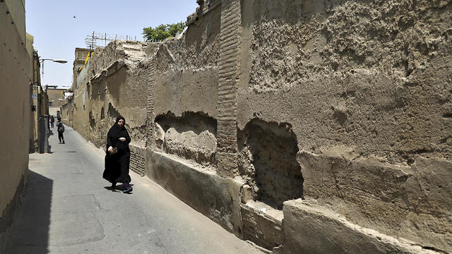 A woman walks in District 12, a poor area plagued by drug addiction and other social problems, in Tehran, July 6, 2019 