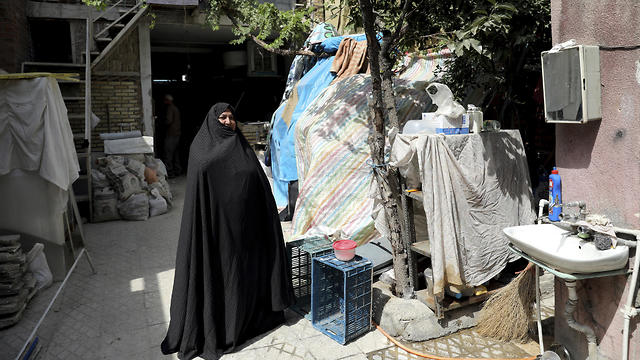 Zeinab Ebrahimi, 56, stands in the courtyard of her house which is under renovation, in the old District 12 of Tehran, July 6, 2019 